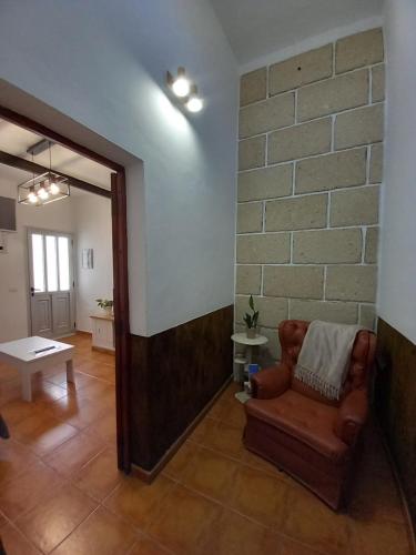 een woonkamer met een bank en een bakstenen muur bij Casa Tomás - Zona Rural in Fasnia