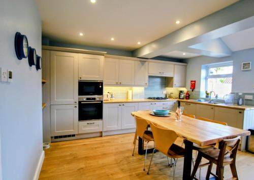 a kitchen with a wooden table and a wooden floor at Nina's Cottage - Southwold in Southwold
