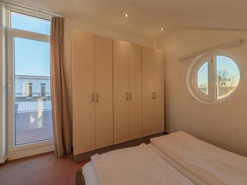 a bedroom with a bed and a large window at elegant eingerichtete Ferienwohnung in Granzow