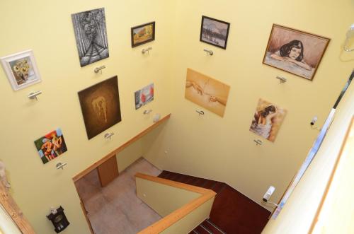 a staircase with a bunch of pictures on the wall at Penzion Folbr in Dlouhá Lhota