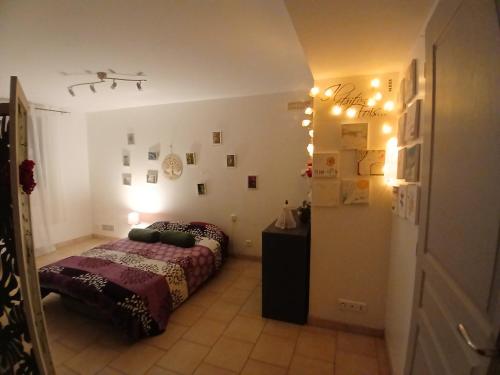 Grand Studio Côté Jardin في Saint-Sernin: غرفة نوم بسرير وطاولة واضاءة