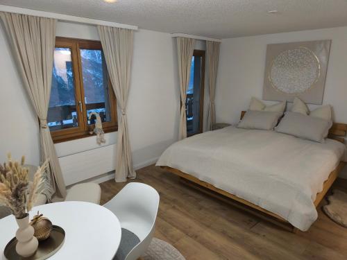 ein Schlafzimmer mit einem großen Bett und einem Tisch und Stühlen in der Unterkunft Apartment Panorama in Eischoll