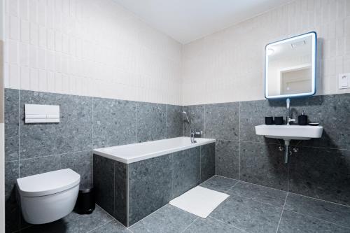 une salle de bains avec baignoire, toilettes et lavabo dans l'établissement Baker Balcony Apartment, à Brno