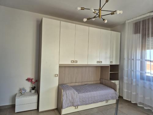 托雷斯港HOMESweetHOME的带床和白色橱柜的卧室