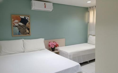a bedroom with two beds with white sheets at Pousada Estrela Dourada in João Pessoa