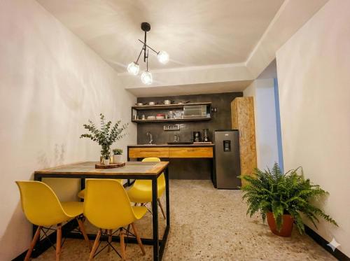 a dining room with a table and yellow chairs at Two-bedroom apartment with AC in the center Oaxaca in Oaxaca City