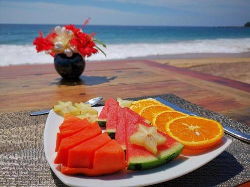 une assiette de fruits sur une table à côté de la plage dans l'établissement Soul Wellness and Ayurveda Resort-All Meals and Treatments Included, à Dikwella