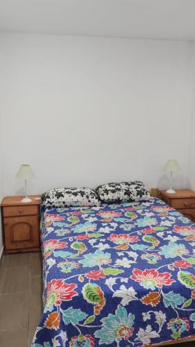 a bedroom with a bed with a colorful comforter at Positiva 3 in Mar de Ajó