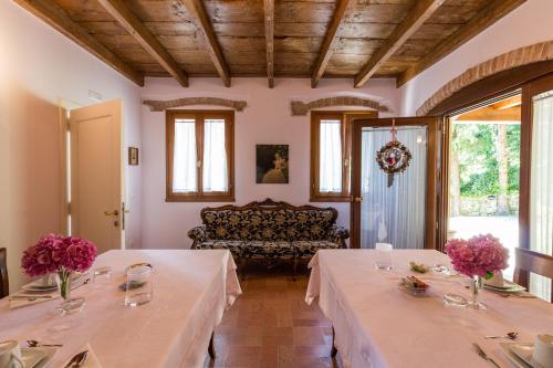 a dining room with two tables and a couch at B&B in Valle in Lumignano