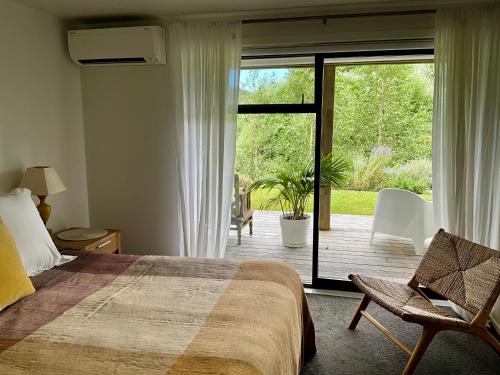 马塔卡纳Garden Apartment的一间卧室，里面有一张床和一扇推拉玻璃门