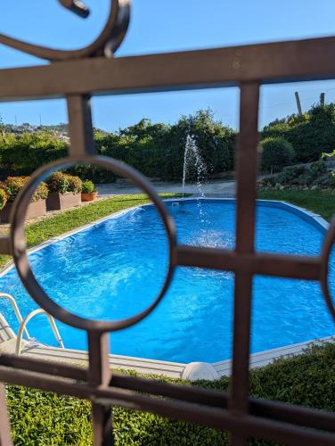 a view through a fence of a swimming pool at 3HOUSE Sol na Eira em Paredes in Rebordosa
