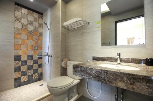 łazienka z toaletą, umywalką i lustrem w obiekcie Successful 168 B&B w mieście Hualian