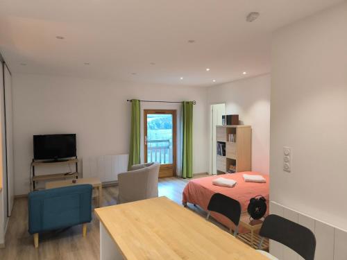 a bedroom with a bed and a table and chairs at Studio rénové avec balcon & vue sur les montagnes in Saint-Clément sur Durance