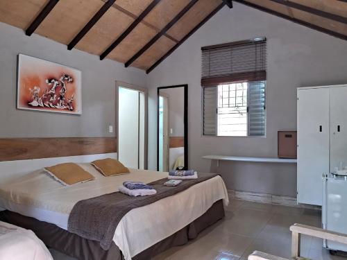a bedroom with a large bed and a bath tub at Pousada Juriti - Eco Hotel in São Roque
