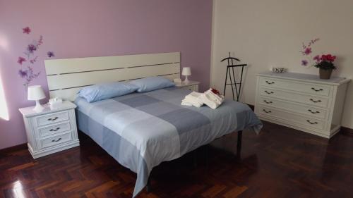 ein Schlafzimmer mit einem Bett, zwei Nachttischen und zwei Kommoden in der Unterkunft Casa Kendra in Montegrotto Terme