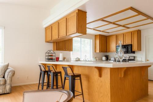 a kitchen with wooden cabinets and bar stools at Silver Sands Den in Hemet