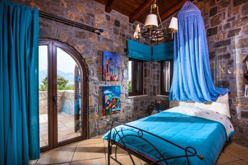- une chambre avec un lit dans un mur en pierre dans l'établissement Villa Belladonna, à Pómbia