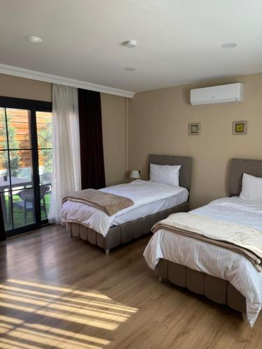 two beds in a hotel room with a window at Some Hotel Antakya in Hatay