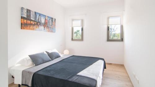 a bedroom with a large bed in a white room at Can Colomer Ferragut in Artá