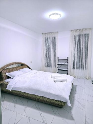 a bedroom with a large bed with white sheets at Casa in Şimnicu de Jos