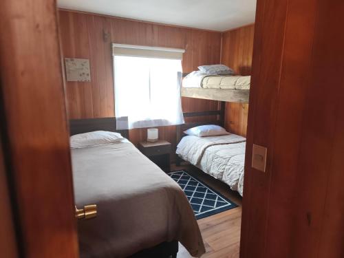 a small room with two bunk beds and a window at Cabaña pasaje las rosas in Pucón