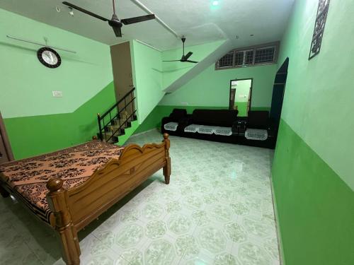 een slaapkamer met een bed en een groene muur bij MB Guest House in Tiruvannamalai