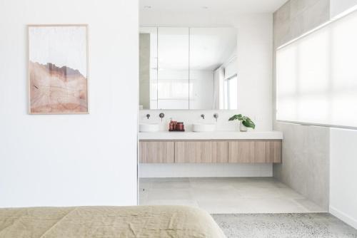 ein weißes Badezimmer mit zwei Waschbecken und einem Spiegel in der Unterkunft Potts Villa Your Serene Beachside Escape in Pottsville