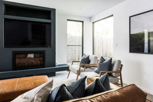 ein Wohnzimmer mit Sofa und Kamin in der Unterkunft Potts Villa Your Serene Beachside Escape in Pottsville