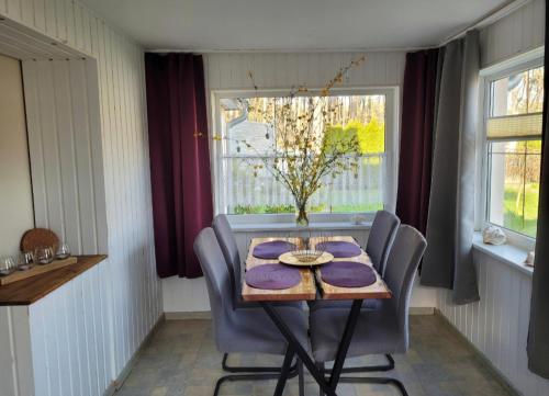 a dining room with a table and chairs and a window at FEWO RENKEN in Trassenheide