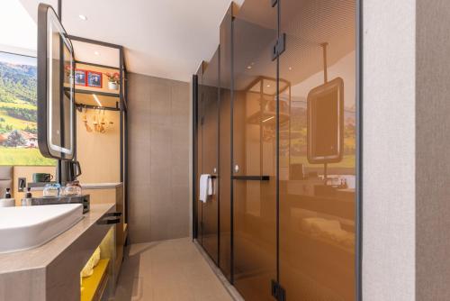 ein Badezimmer mit Waschbecken und Dusche in der Unterkunft Qiuguo Garden Hotel in Dongguan