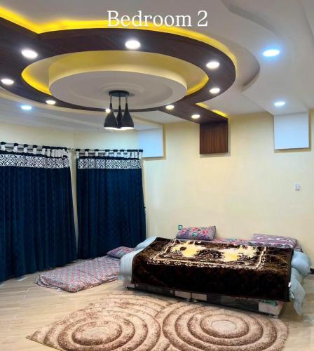 una camera con letto e ampio soffitto di Shahnoor cottages Luxury Apartment ad Abbottābād