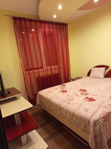 a bedroom with a bed and a red curtain at Harta in cui in Sighetu Marmaţiei