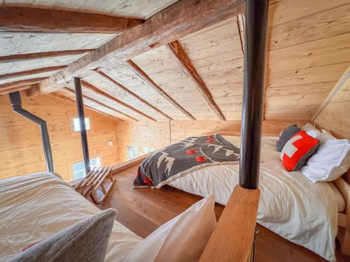 una habitación con dos camas en una cabaña de madera en Le Raidillon Verbier, en Verbier