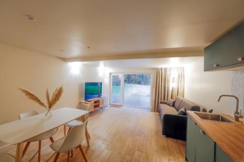 een keuken en woonkamer met een bank en een tafel bij Le clos des tirons in Chambon-sur-Cisse