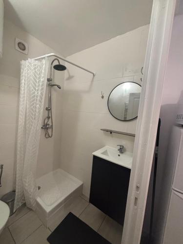 a white bathroom with a sink and a mirror at Logement cosy Essonne in Longjumeau