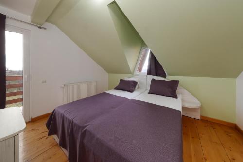a bedroom with a large bed with purple sheets at Casa la Martin in Comarnic