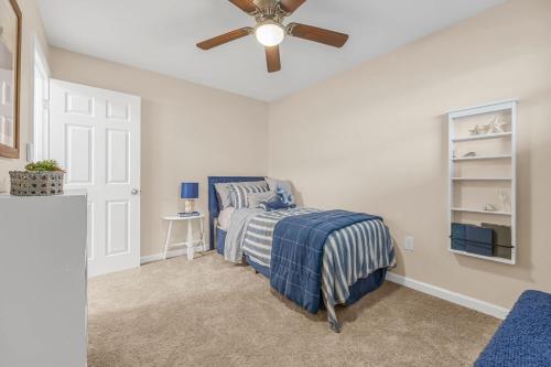 a bedroom with a bed and a ceiling fan at Launch and Lounge Cozy Cape Canaveral Beach Townhome Near Surf and Space in Cape Canaveral