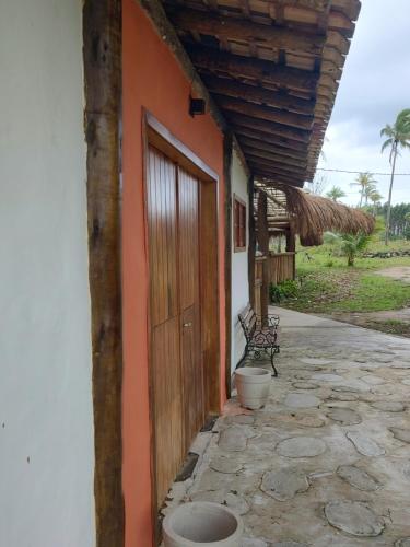 プラドにあるCabana Terra Chã Cumuruxatibaの隣の戸とベンチのある建物