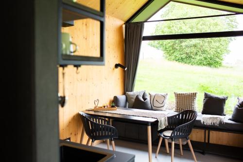 a room with a table and chairs and a window at Tiny House 2 im Allgäu mit gr. Garten, Randlage in Bad Wurzach