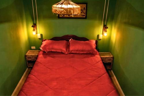 a bedroom with a red bed in a green wall at El KINTU WASI in Vicuña