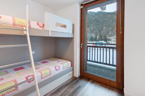 een kleine slaapkamer met stapelbedden en een balkon bij Residenza Viola in Valdidentro