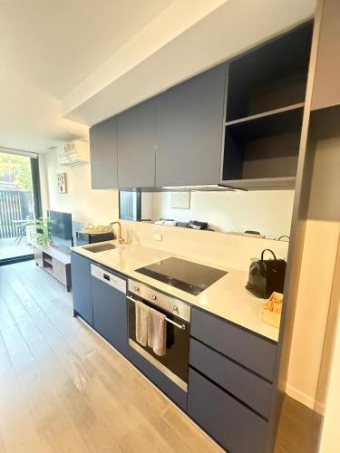 a kitchen with gray cabinets and a stove top oven at CBD - Pool - Sleeps 4 - Parking in Canberra