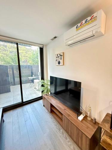 a living room with a large flat screen tv at CBD - Pool - Sleeps 4 - Parking in Canberra