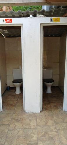 an open bathroom with two toilets in a building at Flor de Lótus Camping in Japaratinga