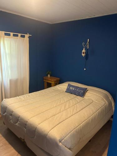a bedroom with a large bed with a blue wall at La Serena in Azul