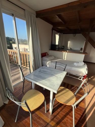 a room with a bed and a table and chairs at Geko Apart Hotel in Mar del Plata