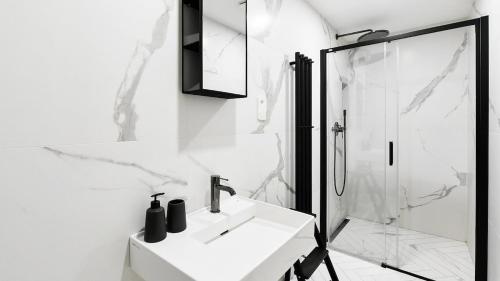 a white bathroom with a sink and a shower at Designer Touch 2-bedroom in Picturesque Area in Golčŭv Jeníkov