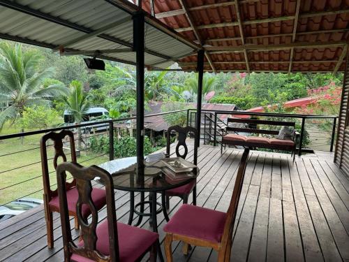 een houten terras met een tafel en stoelen erop bij Cabañas Retiro Del Rio in Guayabal
