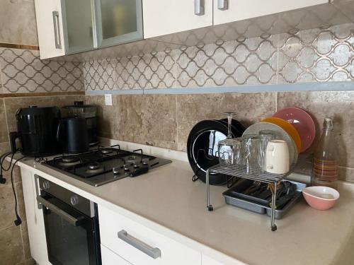 Una encimera de cocina con una estufa y algunos platos. en Prestige, en Dakar
