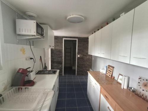 a kitchen with white cabinets and a counter top at Le Repaire de Belette in Coulounieix-Chamiers